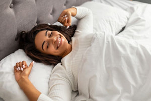 Young woman relaxing under wrinkle-free bamboo sheets